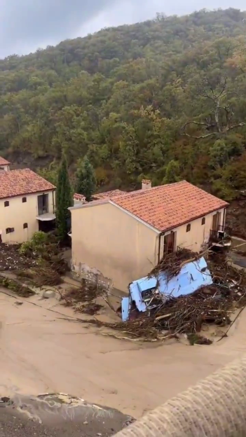 Flooded resort town of Elenite with debris and a partially submerged blue vehicle.