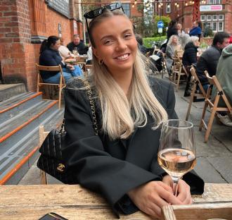 Woman sitting at an outdoor cafe with a glass of rosé.