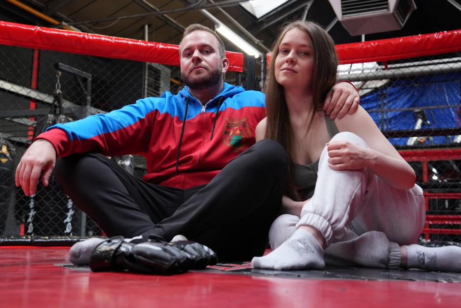 Daryl and Grace from Catching My Stalker, sitting in a fighting ring.