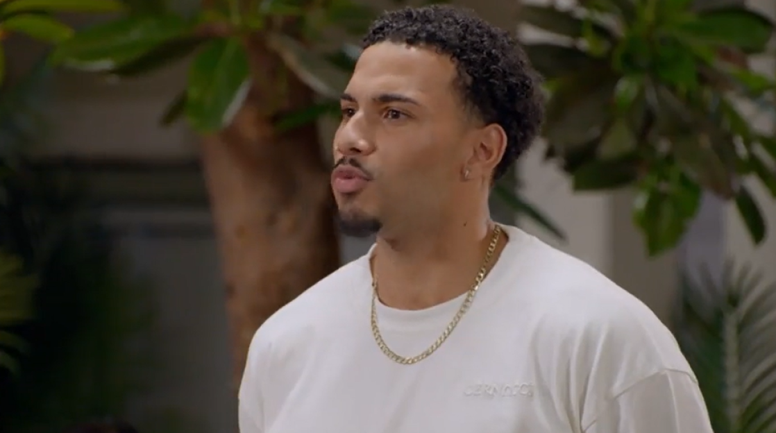 Man wearing a white shirt and gold chain.