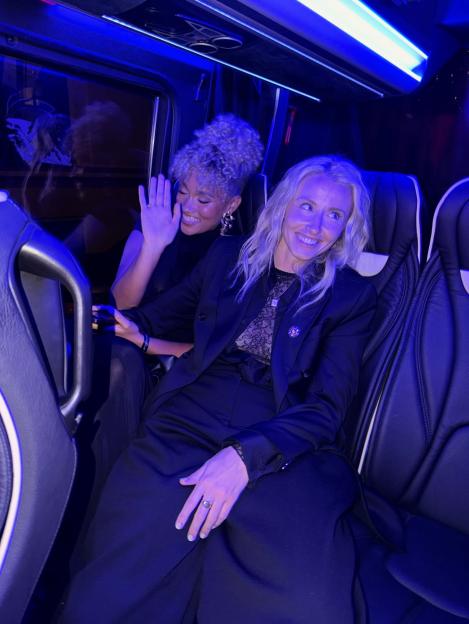 Lionesses captain Leah Williamson and Miss USA, Elle Smith, smiling in a bus.