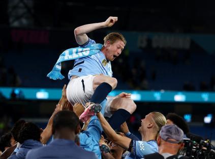 Kevin De Bruyne being hoisted on the shoulders of his teammates after a match.