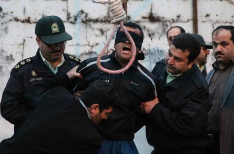 A blindfolded man about to be hanged by police officers.