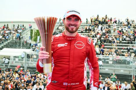 Oliver Rowland holding a trophy after winning the Tokyo E-Prix.