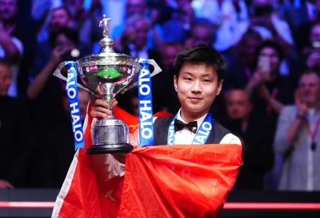 Zhao Xintong holding a snooker championship trophy.