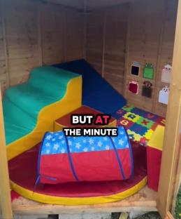 Inside of a wooden shed converted into a child's play area.