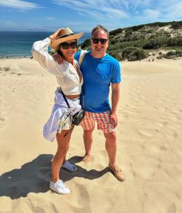 Amanda Holden and Alan Carr on a sandy beach.