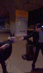 Person appearing to hold a long, thin object to another person's throat.