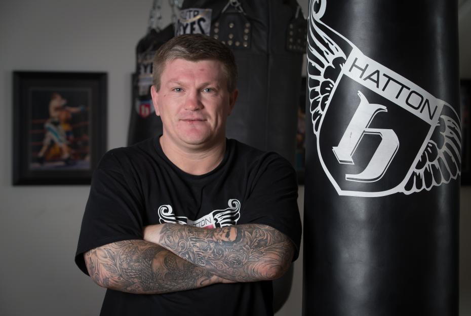 Former world champion Ricky Hatton smiling with his arms crossed during a media workout.