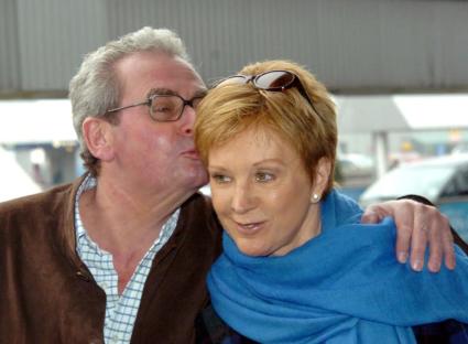 Anne Robinson and her husband John Penrose at an airport.