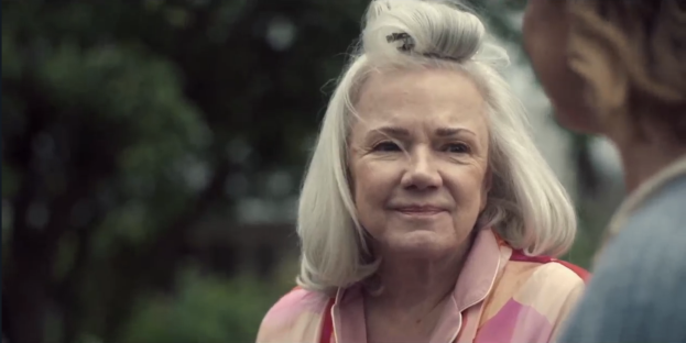 Screenshot of an older woman smiling.
