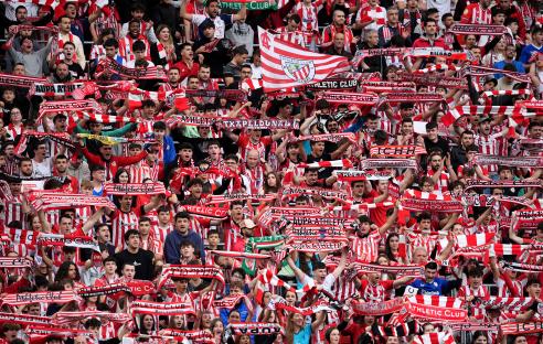 Athletic Club fans holding scarves in stadium stands.