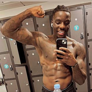 Man flexing in front of lockers.