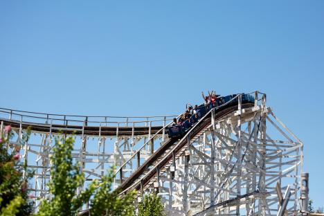 Roller coaster car ascending a wooden roller coaster.
