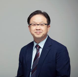 Portrait of a man in a suit and glasses.
