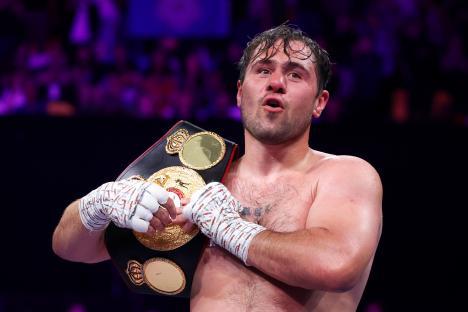 Boxer Dave Allen holding a championship belt after a victory.