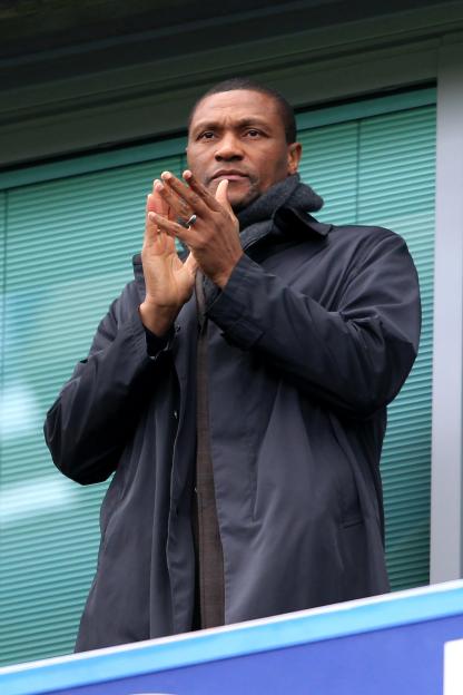 Michael Emenalo, Chelsea's technical director, claps in a stadium.