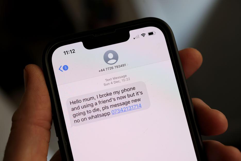 A phone displaying a scam text message that reads, "Hello mum, I broke my phone and using a friend's now but it's going to die, pls message new no on whatsapp 07342131714."