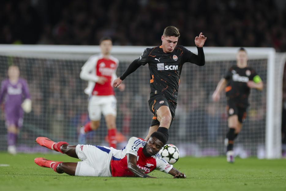 Soccer player from Shakhtar Donetsk tackling an Arsenal player.