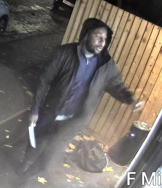 A man with a knife walking on a street at night.