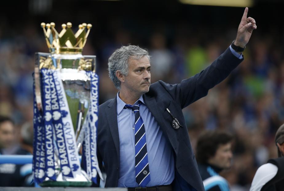 Chelsea manager Jose Mourinho gestures next to the Premier League trophy.