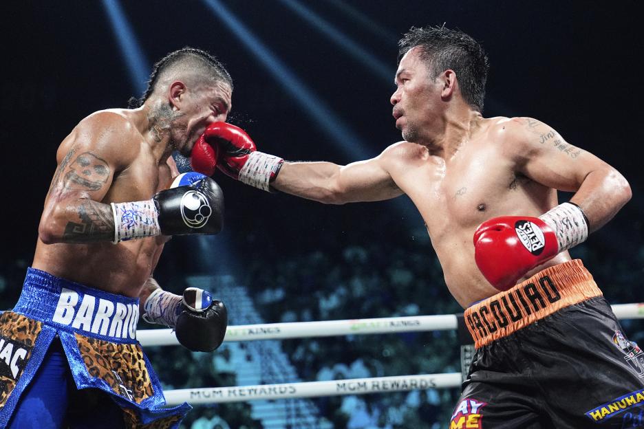 Mario Barrios, left, receives a punch to the face from Manny Pacquiao.