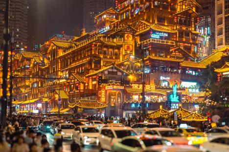 Night view of Hongyadong, Chongqing, China, illuminated hillside buildings and bridge with traffic.