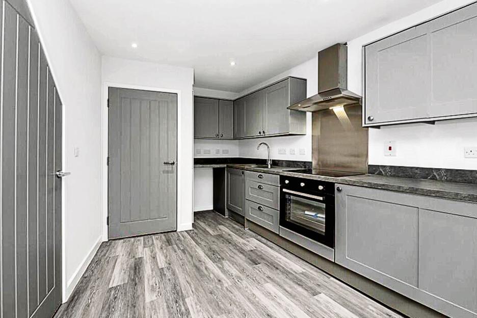 Modern gray kitchen with stainless steel appliances.
