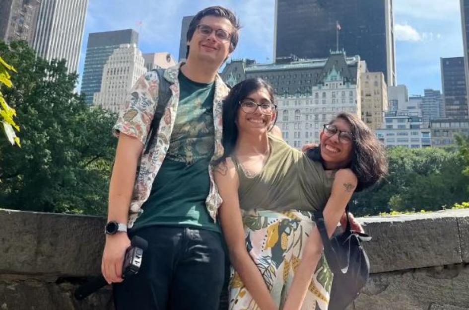 Carmen and Lupita Andrade and Daniel McCormack posing in front of tall city buildings.