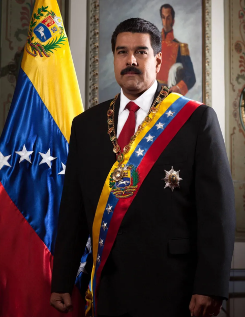 Nicolás Maduro in formal wear with Venezuelan flag.