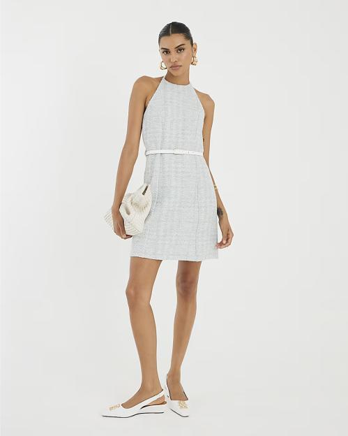 Model wearing a gray halter mini dress and white shoes.