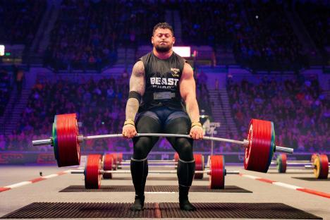 Strongman competitor preparing to lift a barbell.