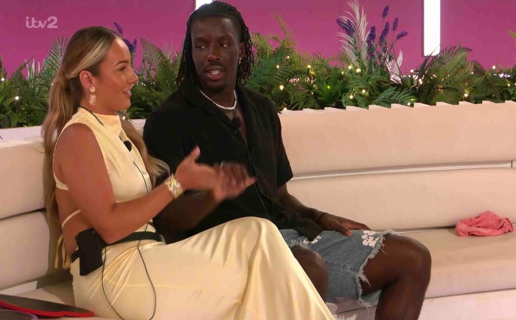Meg and Dejon on a Love Island couch.