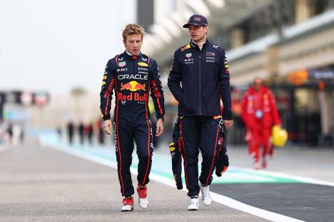 Liam Lawson and Max Verstappen of Oracle Red Bull Racing walking in the pit lane.