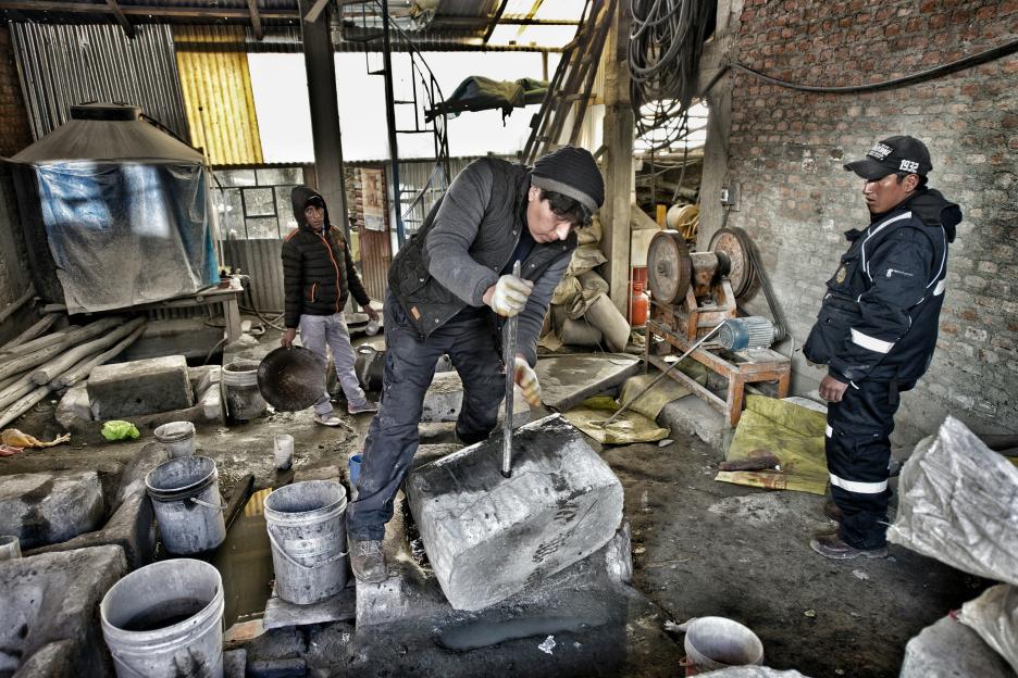 Miners crushing stones in a high-altitude Peruvian mine.