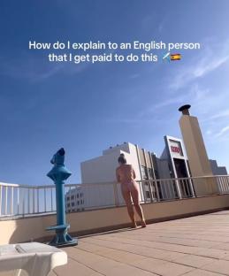 Woman in bikini on a rooftop terrace in Spain.