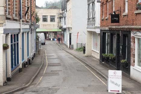 A street in Nailsworth, Gloucestershire, with shops and a damaged gas main.