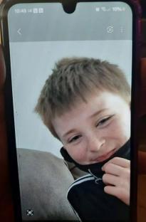 Close-up photo of a young boy smiling.