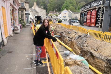 Woman stands by a damaged gas main in Nailsworth, Gloucestershire.