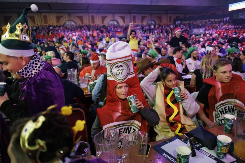 Fans dressed in costumes, including a ketchup bottle and hot dog, attend the opening session of the Paddy Power World Darts Championship.