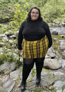 Photo of Beckie Bold wearing a black top and yellow plaid skirt.