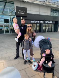 Family of five at an airport terminal.