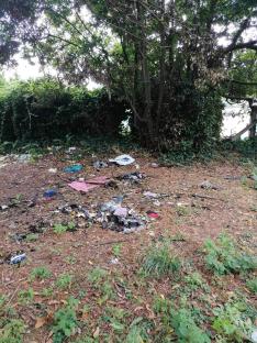 Fly-tipped rubbish and drug paraphernalia near tennis courts.