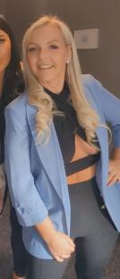 Woman in a light blue blazer and black top.