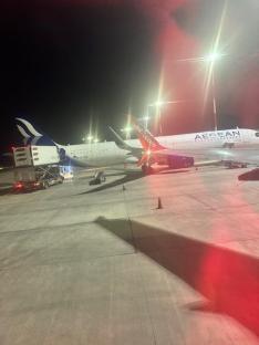 Two airplanes at night on a tarmac.