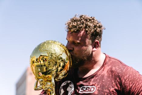 Tom Stoltman kissing the World's Strongest Man trophy.