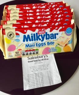 A stack of Milkybar Mini Eggs chocolate bars with a receipt.