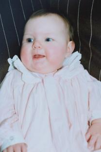 Photo of a baby girl in a pink outfit.