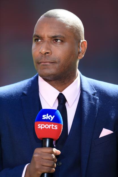 Clinton Morrison, Sky Sports pundit, holding a microphone.