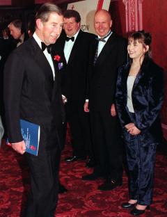 a man in a tuxedo is standing next to a girl in a blue suit
